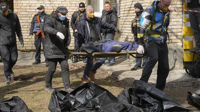 Des volontaires rassemblent les corps des personnes abattues à Boutcha, 04.04.2022. [AP/Keystone - Efrem Lukatsky]