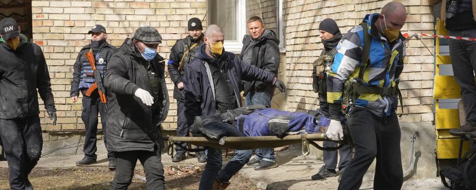 Des volontaires rassemblent les corps des personnes abattues à Boutcha, 04.04.2022. [AP/Keystone - Efrem Lukatsky]