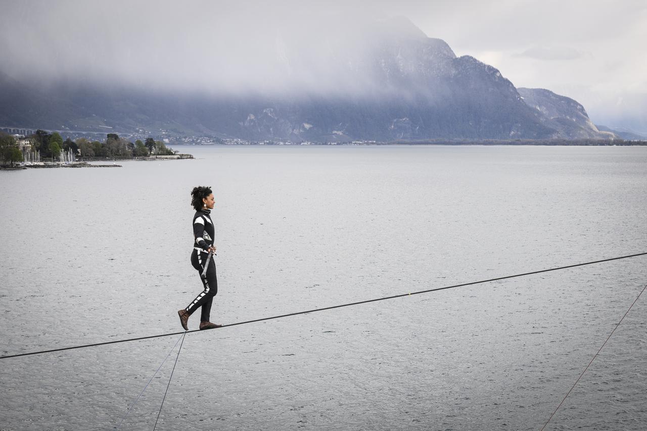 La funambule de la compagnie Basinga, Tatiana-Mosio Bongonga, traverse la place du marché de Vevey sur un câble de 180 mètres de long à une hauteur de 20 mètres. [KEYSTONE - Gabriel Monnet]