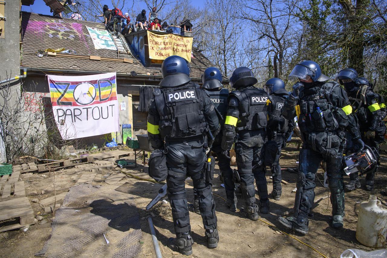 Des membres des forces de l'ordre lors de l'évacuation de la ZAD du Mormont. [Keystone - Jean-Christophe Bott]