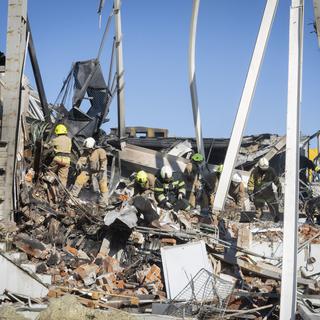 Les pompiers des services d'urgence de l'État ukrainien travaillent pour enlever les débris dans un centre commercial incendié après une attaque à la roquette à Krementchouk, en Ukraine, le mardi 28 juin 2022. [AP Photo/ Keystone - Efrem Lukatsky]