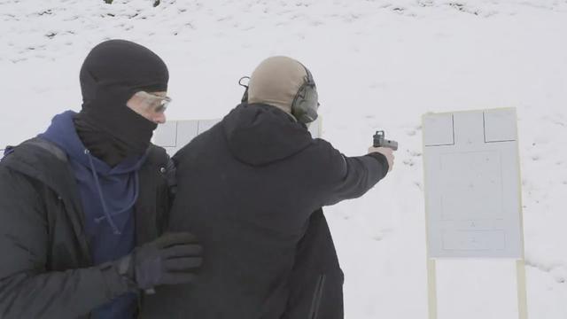 Un soldat du DRA-10 s'entraîne à la garde corporelle armée, un autre militaire jouant le rôle de la personne à protéger. [RTS - Temps Présent]