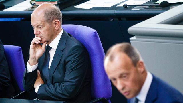 Le chancelier allemand Olaf Scholz regarde le discours du président du parti et de la faction de l'Union chrétienne-démocrate (CDU), Friedrich Merz (R), après avoir prononcé une déclaration du gouvernement au Parlement allemand, le Bundestag, à Berlin, en Allemagne, le 22 juin 2022. [EPA/KEYSTONE - Clemens Bilan]