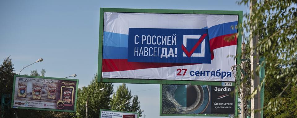 Un panneau avec l'inscription "Avec la Russie pour toujours" installé avant la tenue du référendum d'annexion à Lougansk. [Keystone - AP Photo]