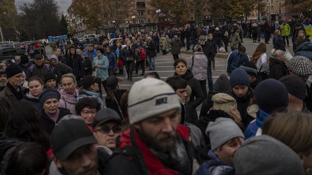 Des personnes font la queue pour recevoir des dons alimentaires dans le centre-ville de Kherson, dans le sud de l'Ukraine, le 16 novembre 2022. [Keystone - AP Photo/Bernat Armangue]