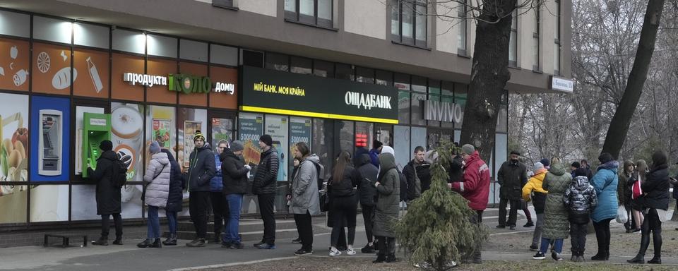 Les ukrainiens font la queue pour retirer leur argent. [Keystone - AP Photo/Efrem Lukatsky]