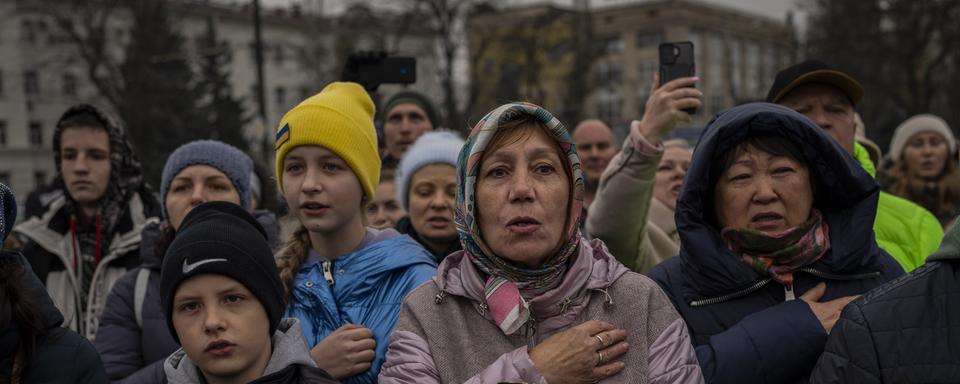 Des habitants de Kherson chantent l'hymne ukrainien le 20 novembre. [Keystone - AP Photo/Bernat Armangue]