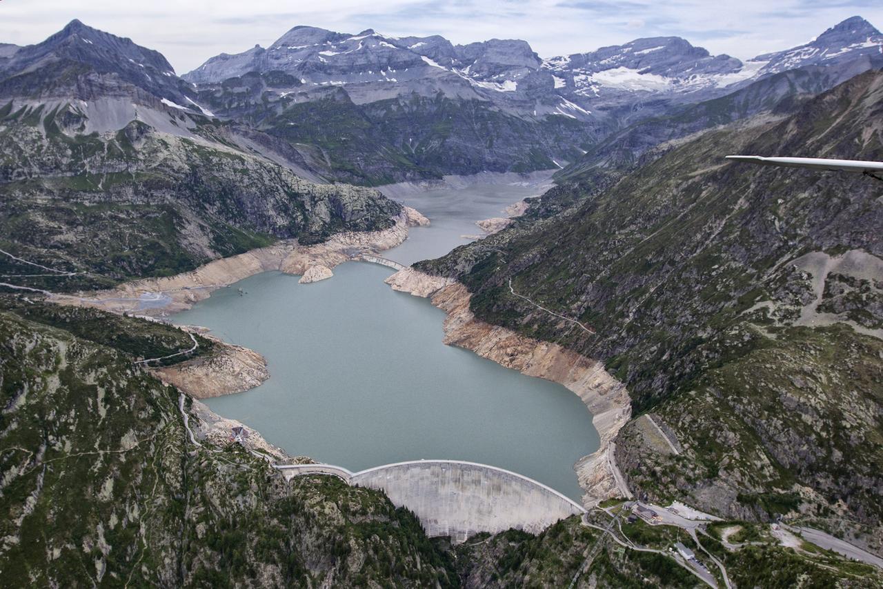 Le barrage d'Emosson (au premier plan) et l'ancien barrage de Barberine, en partie submergé, au milieu du lac. Le barrage du Vieux-Emosson est hors-cadre, sur la gauche de l'image. [Keystone - Alessandro Della Bella]