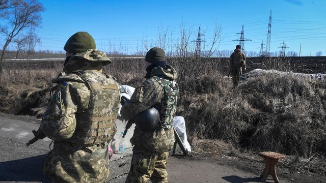 Des soldats ukrainiens patrouillent sur la route près de Kharkiv, en Ukraine, le 23 mars 2022. [EPA/KEYSTONE - Andrzej Lange]