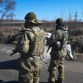 Des soldats ukrainiens patrouillent sur la route près de Kharkiv, en Ukraine, le 23 mars 2022. [EPA/KEYSTONE - Andrzej Lange]