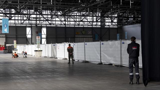 Des enfants réfugiés ukrainiens jouent devant les caisses de l'abri d'urgence pour réfugiés ukrainiens dans la halle 1 de Palexpo, mardi 12 avril 2022 à Genève. [KEYSTONE - Salvatore Di Nolfi]