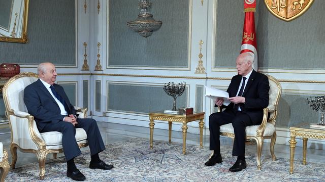 Une photo polycopiée, mise à disposition par le service de presse de la présidence tunisienne, montre le président du Comité consultatif pour la nouvelle République, Sadik Beliyd (G), présentant le projet de texte de la recommandation pour la nouvelle constitution préparé par le comité au président tunisien Kais Saied (D), au Palais de Carthage à Tunis, Tunisie, le 20 juin 2022. [EPA/TUNISIA PRESIDENCY / KEYSTONE]