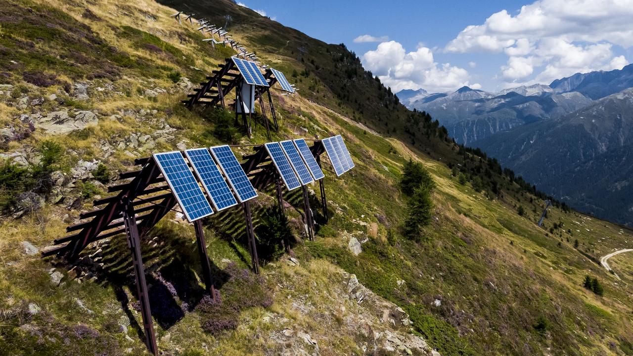 Une vue sur les panneaux solaires installés sur des paravalanches dans les Alpes le mercredi 3 août 2022 à Bellwald (VS). [Keystone - Jean-Christophe Bott]