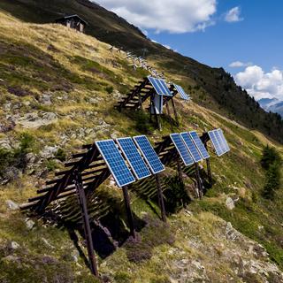 Une vue sur les panneaux solaires installés sur des paravalanches dans les Alpes le mercredi 3 août 2022 à Bellwald (VS). [Keystone - Jean-Christophe Bott]
