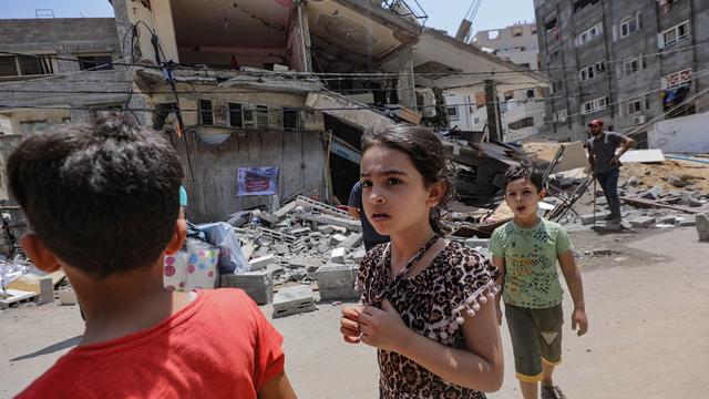 Des enfants devant l'un des bâtiments détruits par Israël à Gaza, 09.08.2022. [EPA/Keystone - Mohammed Saber]