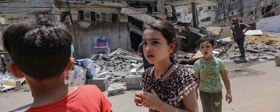 Des enfants devant l'un des bâtiments détruits par Israël à Gaza, 09.08.2022. [EPA/Keystone - Mohammed Saber]