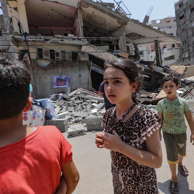 Des enfants devant l'un des bâtiments détruits par Israël à Gaza, 09.08.2022. [EPA/Keystone - Mohammed Saber]