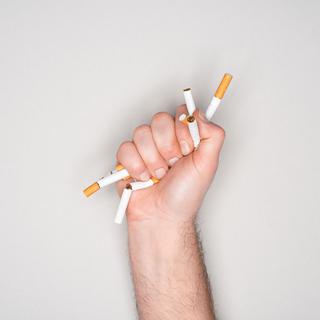 Gros plan sur un poing qui écrase des cigarettes. [Depositphotos - VadimVasenin]