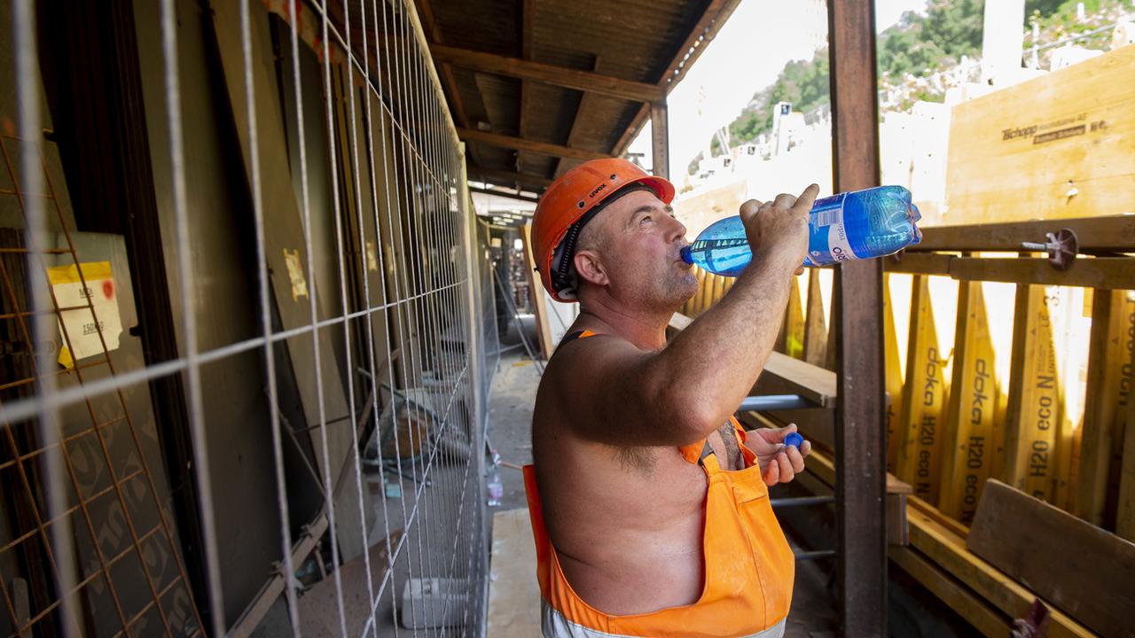 Un ouvrier sur un chantier s'hydrate pendant un épisode de canicule. [Keystone - Francesca Agosta]