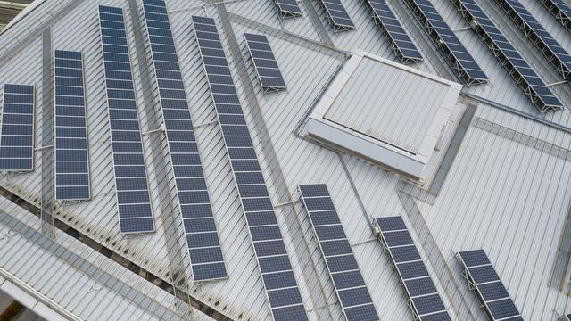 Panneaux solaires sur le toit d'un immeuble. [Depositphotos - leungchopan]