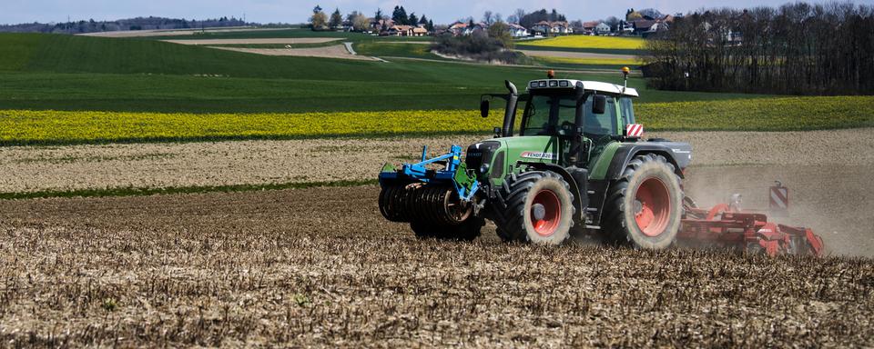 Un tracteur dans la campagne vaudoise en avril 2021. [Keystone - Jean-Christophe Bott]