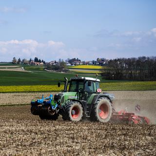 Un tracteur dans la campagne vaudoise en avril 2021. [Keystone - Jean-Christophe Bott]