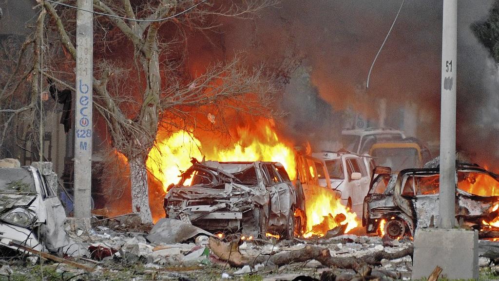 Des voitures en feu après l'attentat à la bombe contre l'hôtel Ambassador à Mogadiscio, en Somalie, revendiqué par le groupe affilié à Al Qaïda al-Shabaab en 2016. Image d'illustration. [AFP - MOHAMED ABDIWAHAB]