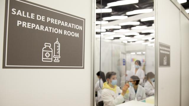 Dans la salle de préparation le staff médical prépare des doses de vaccins Moderna pour la vaccination des personnes contre le coronavirus COVID-19, lors du premier jour d'ouverture du Centre de vaccination de Palexpo, ce lundi 19 avril 2021 à Genève. [KEYSTONE - Salvatore Di Nolfi]