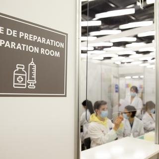 Dans la salle de préparation le staff médical prépare des doses de vaccins Moderna pour la vaccination des personnes contre le coronavirus COVID-19, lors du premier jour d'ouverture du Centre de vaccination de Palexpo, ce lundi 19 avril 2021 à Genève. [KEYSTONE - Salvatore Di Nolfi]