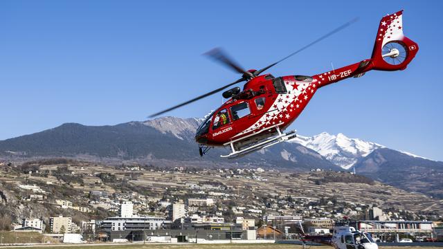 Un hélicoptère de la compagnie Air Glaciers décolle de la base pour un sauvetage en montagne. [Keystone - Jean-Christophe Bott]