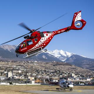 Un hélicoptère de la compagnie Air Glaciers décolle de la base pour un sauvetage en montagne. [Keystone - Jean-Christophe Bott]