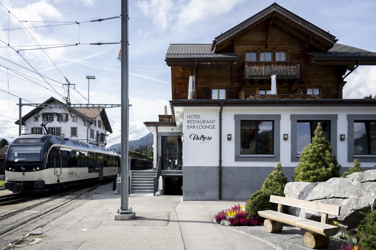 Un train de la compagnie du Montreux Oberland bernois (MOB) passe à côté de l'hôtel-restaurant "Valrose" à Rougemont. [Keystone - Anthony Anex]
