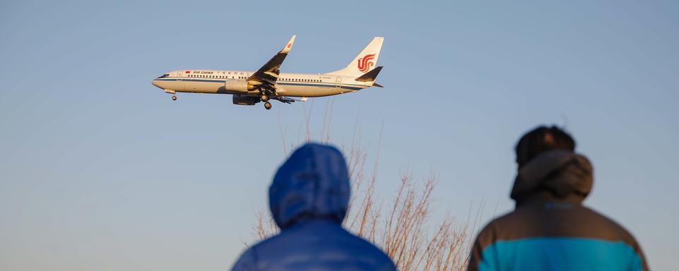 Un avion passe au-dessus de Pékin alors que le gouvernement Chinois a décidé la fin de la quarantaine COVID obligatoire à l'arrivée sur son territoire. [EPA/Keystone - WU HAO]