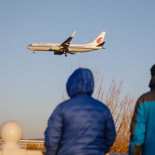 Un avion passe au-dessus de Pékin alors que le gouvernement Chinois a décidé la fin de la quarantaine COVID obligatoire à l'arrivée sur son territoire. [EPA/Keystone - WU HAO]
