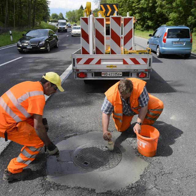 Des ouvriers effectuent des travaux d'entretien sur la route cantonale entre Lausanne et Moudon. [Keystone - Laurent Gillieron]