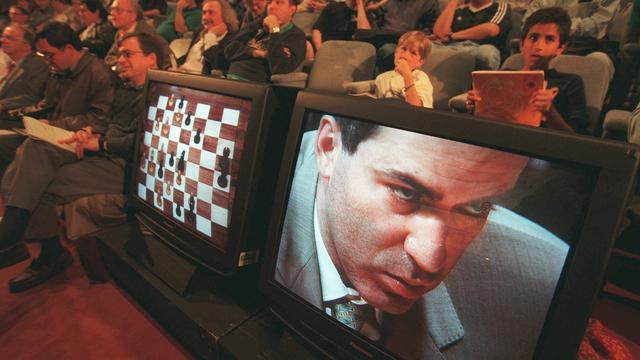 JUn public regarde Garry Kasparov sur un écran de télévision en train de réfléchir à son prochain coup contre Deep Blue, l'ordinateur d'échecs d'IBM, lors de la première partie de leur match revanche de six matchs, samedi 3 avril 1997, à New York. [KEYSTONE/AP - AdamNadel]