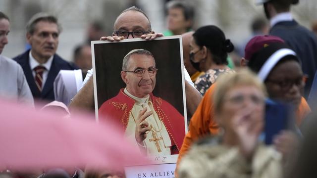 Un fidèle tient une photo du pape Jean-Paul 1er lors de la cérémonie de béatification au Vatican. [Keystone/AP Photo - Andrew Medichini]