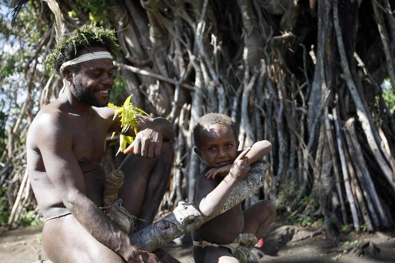 Deux villageois sous un figuier des banians, sur l'île de Tanna. Vanuatu, le 31 mai 2015. [Keystone/AP photo - Nick Perry]