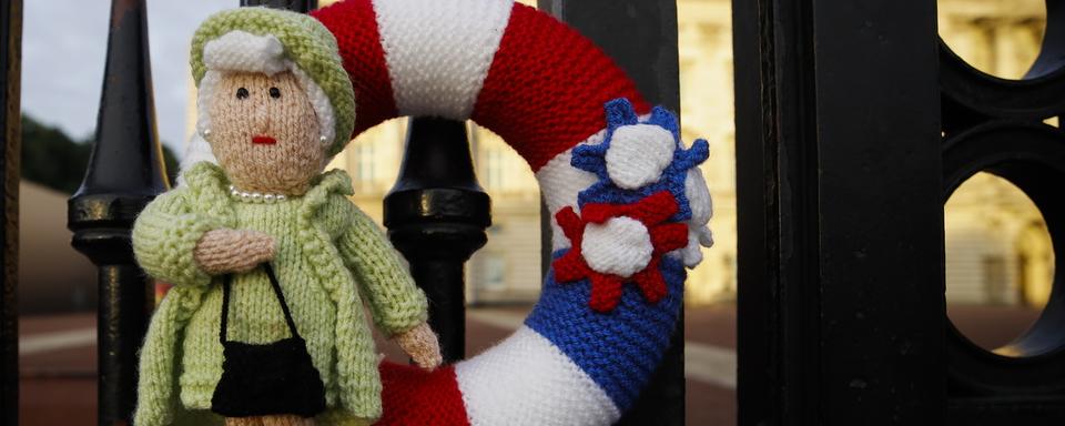 Lundi 12 septembre: aux grilles du palais de Buckingham, une petite reine Elizabeth II en tricot rend hommage à la souveraine défunte.