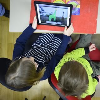 Des élèves sur une tablette dans une école vaudoise en février 2022. [Keystone - Laurent Gillieron]