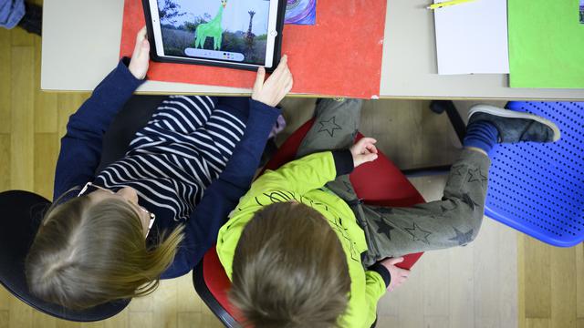 Des élèves sur une tablette dans une école vaudoise en février 2022. [Keystone - Laurent Gillieron]