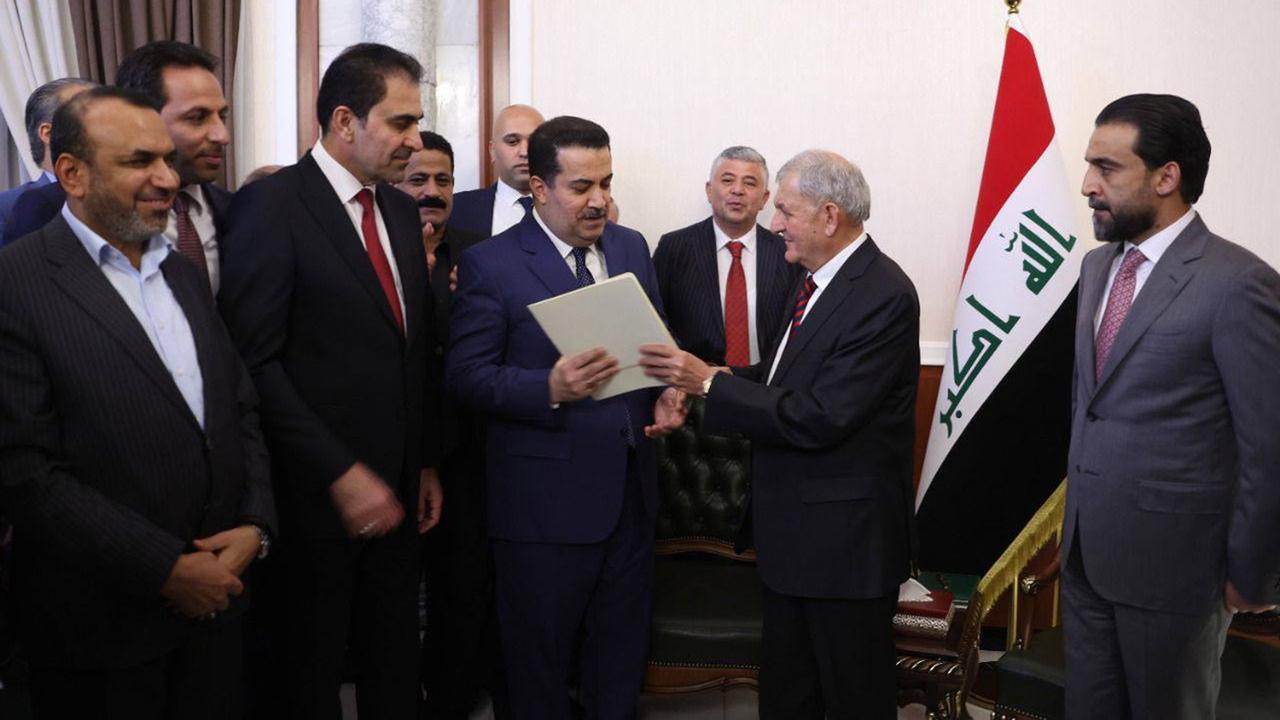 Le nouveau président irakien Abdul Latif Rashid (2e depuis la droite) remet la lettre de mission pour former un nouveau gouvernement au Premier ministre nommé Mohammed Shia Al Sudani (à gauche), le 13 octobre 2022. [Keystone - Bureau des médias du Parlement irakien]