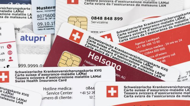 Plusieurs cartes d'assurance maladie en Suisse. [Keystone - Christian Beutler]