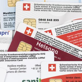 Plusieurs cartes d'assurance maladie en Suisse. [Keystone - Christian Beutler]