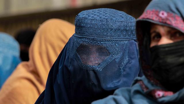 Une femme afghane vêtue d'une burqa marche sur une route à Kaboul, en Afghanistan, le 27 décembre 2021. [EPA/KEYSTONE - Stringer]