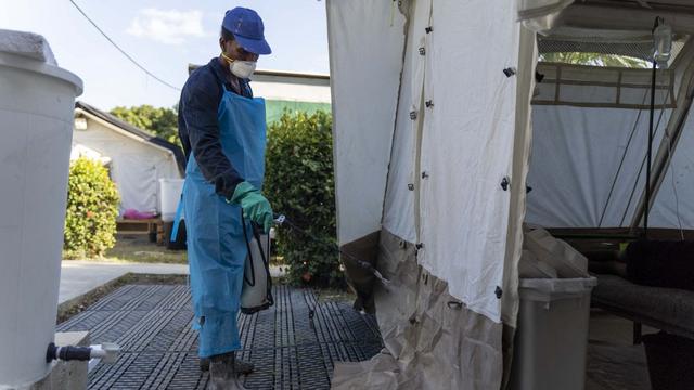 Un homme désinfecte une tente où sont soignés des malades du choléra à Port-au-Prince, en Haïti, le 7 octobre 2022. [AFP - RICHARD PIERRIN]