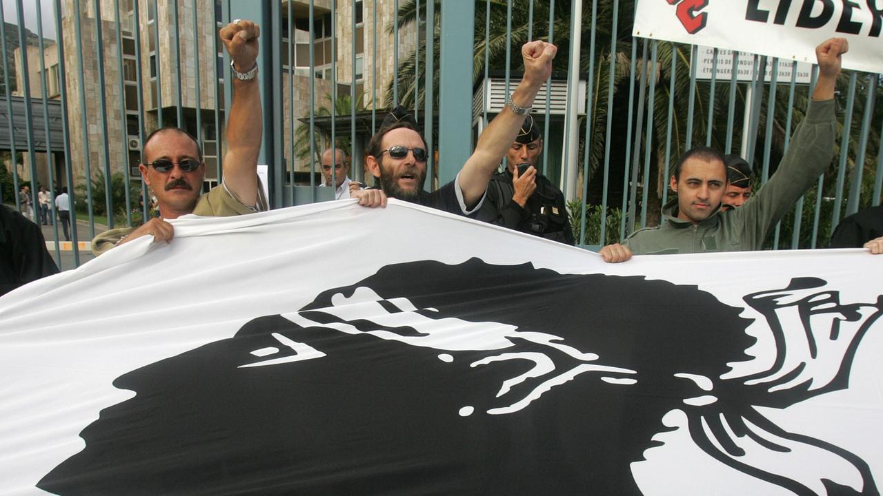 Manifestant tenant le drapeau corse en 2005. [Keystone - Jean Pierre Belzit]