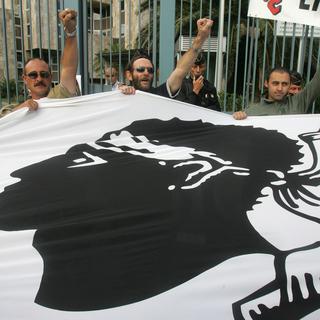 Manifestant tenant le drapeau corse en 2005. [Keystone - Jean Pierre Belzit]