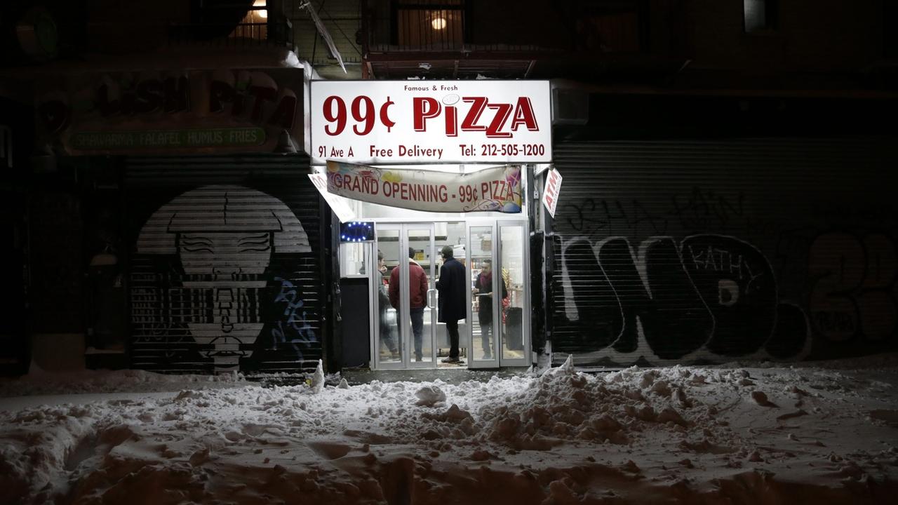 A New York, la traditionnelle part de pizza à moins de 1 dollar est menacée. [Keystone - EPA/Jason Szenes]