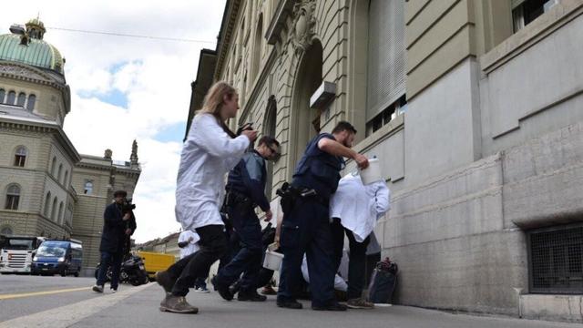 Dix-sept scientifiques suisses se sont rendus mercredi sur la Place fédérale à Berne et ont collé des parties du rapport des experts climatiques de l'ONU (GIEC), ainsi que d'autres extraits de recherches, sur les murs du Palais fédéral. La police veillait au grain. [SCIENTIST REBELLION]